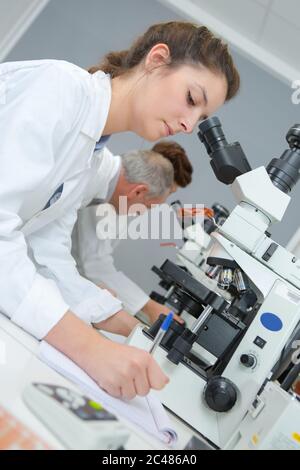 young female scientist writes report in modern laboratory Stock Photo