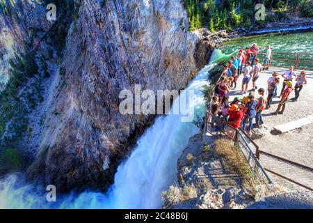 Wyoming, USA - Aug. 27, 2019: Visitors stand at the Brink of Lower Falls at Yellowstone National Park to watch rushing waters from the Yellowstone Riv Stock Photo