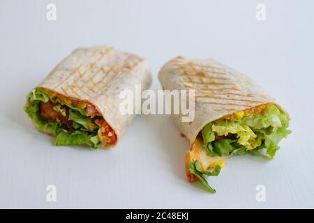 Tortilla with fried chicken meat and vegetables isolated on white background Stock Photo