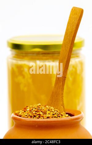 Bee pollen granules in a clay pot. Selective focus with shallow depth of field. Stock Photo