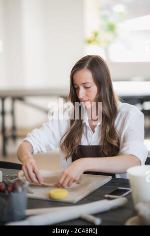 Artisan potter prepares material clay for pottery. Man knead clay before  molding. Male sculptor is pugging and kneading clay for creating ceramics  in Stock Photo - Alamy