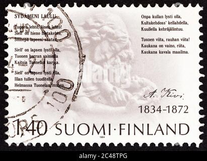 FINLAND - CIRCA 1984: A stamp printed in Finland shows Mother and Child (Waino Aaltonen) and lines from Song of my Heart, circa 1984. Stock Photo