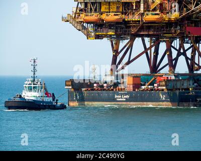 Lead tug towing the topside of the Shell/Esso Brent Alpha platform arriving in the River Tees for recycling after 44 years service in the Northern Nor Stock Photo