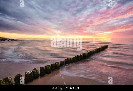 Seascape with an old wooden breakwater at sunset, long exposure picture. Stock Photo