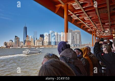 People look at the Manhattan skyline from the Staten Island Ferry. New York City, USA. Stock Photo