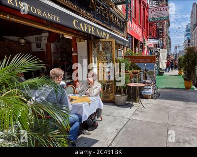 Man and woman sit at the outside table in Caffe Napoli on Mulberry street. Little Italy, Lower Manhattan, New York City, USA. Stock Photo