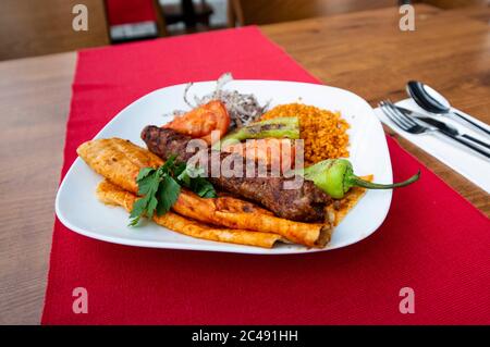 Turkish Adana Kebap With bulgur pilaf And Vegetables Served On A Plate Stock Photo