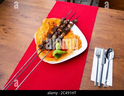 Turkish kebab lamb meat on skewer. with vegetables and rice on a serving plate.Turkish Sis (sish) Kebab / shish kebab Stock Photo