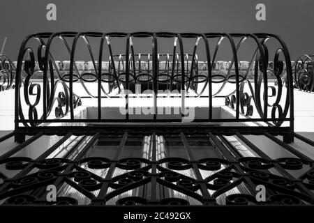Low angle greyscale shot of the patterned iron railings of a window Stock Photo