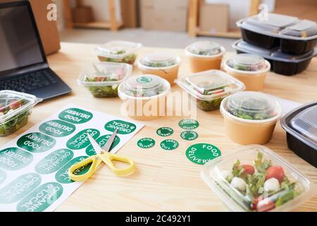Image of organic healthy food in boxes on wooden table at office Stock Photo