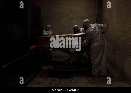 Mexiko Stadt, Mexico. 24th June, 2020. Employees in protective suits carry a coffin. In the San Isidro crematorium, an average of 20 people per week have died of coronavirus infection since the beginning of the pandemic. Credit: Jacky Muniello/dpa/Alamy Live News Stock Photo