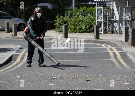 Volunteers clean up in Overton Road, Angell Town, Brixton, south London, where riots and violent confrontations with police took place overnight. Fifteen officers were injured and four people were arrested following the incident. Stock Photo