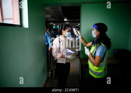 Kathmandu, Nepal. 25th June, 2020. A staff of Buddha Air measures the temperature of a passenger during a mock drill to make necessary preparations for the resumption of domestic and international flights starting August 1 as Nepal has suspended all passenger flights enforcing the lockdown to contain the spread of coronavirus disease at Tribhuvan International Airport in Kathmandu, Nepal on Thursday, June 25, 2020. Credit: Skanda Gautam/ZUMA Wire/Alamy Live News Stock Photo