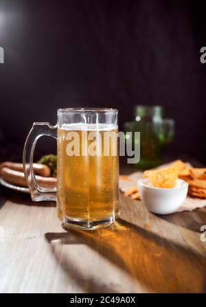 A mug of light beer on a dark background with snacks. Close-up Stock Photo