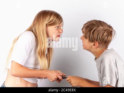 A boy and a girl arguing over a smartphone Stock Photo