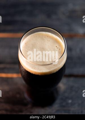 Top view a glass of porter beer on a dark pub table Stock Photo