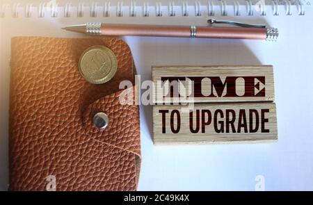 time to upgrade text on a wooden blocks, brown leather wallet, coins and pen put on copybook. Business technologies project concept Stock Photo