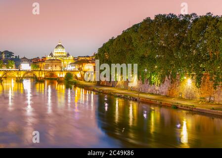 St Peters Basilica in Vatican and Ponte Sant'Angelo Bridge over Tiber River at dusk. Romantic evening cityscape of Rome, Italy. Stock Photo