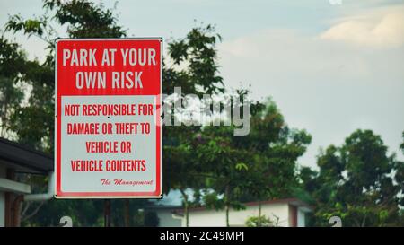 Park at your own risk sign board at housing area. Sign board for indicating of not responsible for damage or theft to vehicle or vehicle contents Stock Photo