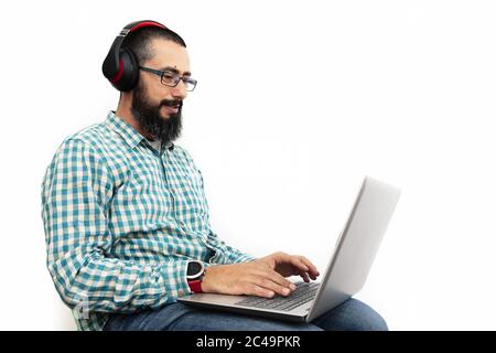 man with headphone isolated on white background typing on a laptop, communication and technology concept Stock Photo