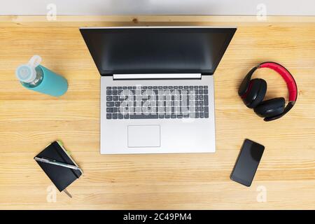 top view of a workspace with a laptop, headset and phone, work from home concept Stock Photo