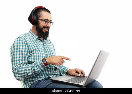 man isolated on white background laughing as he points at his computer screen, communication and technology concept Stock Photo