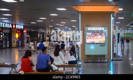 Seoul, South Korea - People watching TV news at waiting room in Seoul Station. Major railway station. Television sponsored by Samsung. Stock Photo