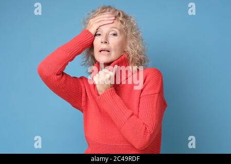Sick exhausted female touching forehead, having fever or headache Stock Photo