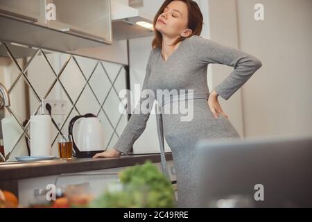 Tired pregnant woman feeling bad and closing her eyes Stock Photo