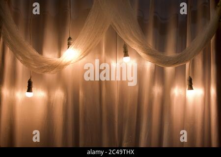 light bulb with yellow light and white cloth as a wedding room decoration. can be used as background and wallpaper Stock Photo