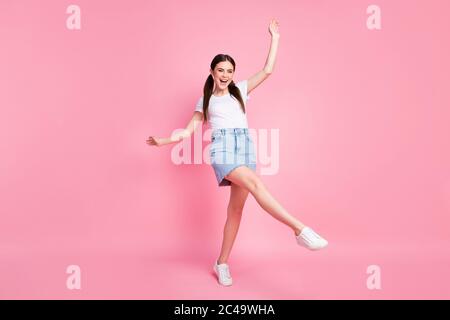 Full length photo of pretty lady enjoy sunny day weather dancing students party excited wear casual white t-shirt mini denim skirt shoes isolated Stock Photo