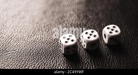Three dices on the black table. BW photo Stock Photo
