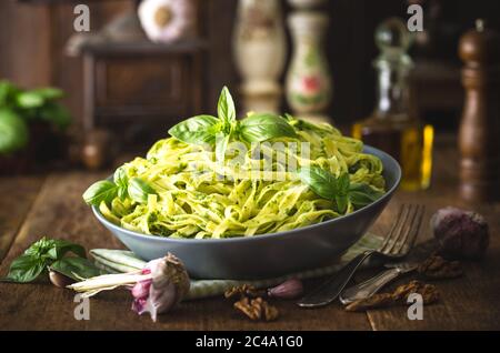 Pasta spaghetti with pesto sauce and fresh basil leaves in black stone ...