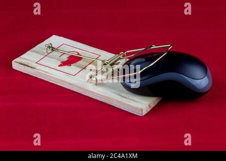 An old fashioned wooden rodent trap with computer mouse on a red background Stock Photo
