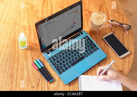 Coronavirus. Person making notes while working at home during quarantine..Top View Stock Photo