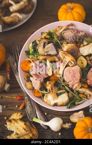 Homemade fried mushrooms, pork and vegetables in the plate Stock Photo