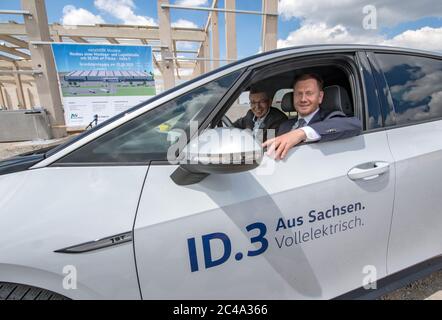 25 June 2020, Saxony, Meerane: Reinhard de Vries (l), Managing Director Volkswagen Saxony, and Michael Kretschmer (CDU), Prime Minister of Saxony, are sitting in front of the construction site for a new logistics hall in the Meerane industrial park in a VW ID.3 Volkswagen. Saxony will rent this 25,000 square meter hall for the production of the fully electric vehicles of the ID family. Project developer Metawerk expects at least 2,000 jobs to be created in the industrial park by 2022, and around 700 million euros to be invested. Six companies from the logistics and automotive industries have a Stock Photo