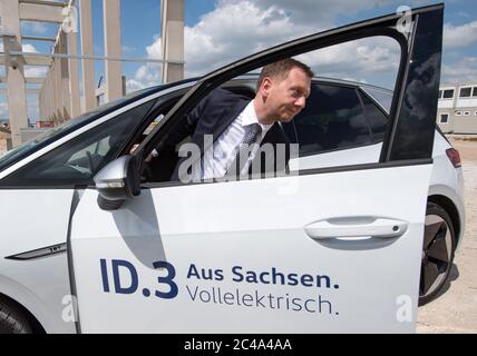 25 June 2020, Saxony, Meerane: Michael Kretschmer (CDU), Prime Minister of Saxony, climbs out of a VW ID.3 at the construction site for a new logistics hall in the Meerane industrial park. Volkswagen Saxony will rent this 25,000 square meter hall for the production of the fully electric vehicles of the ID family. Project developer Metawerk expects at least 2,000 jobs to be created in the industrial park by 2022 and around 700 million euros to be invested. Six companies from the logistics and automotive industries have already been located in the industrial park, which focuses on electromobilit Stock Photo