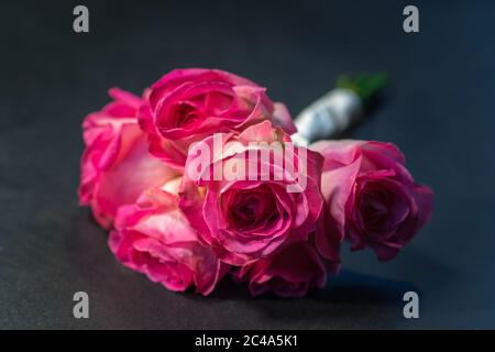 Bouquet of pink roses lying on a dark grey floor Stock Photo