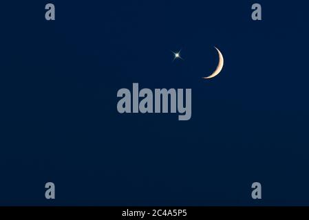 Crescent moon with star on dark-blue sky, picture for Ramadan or Ramazan Stock Photo