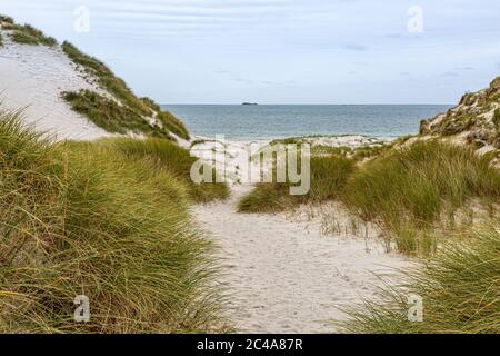Looking through marram grass covered sand dunes towards the sea, on the Hebridean island of Berneray Stock Photo