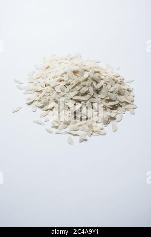 Raw Flattened Rice or Thick or thin Rice Flakes for Namkeen Chivda snacks or Aloo Poha for Indian Breakfast, served in a bowl Stock Photo