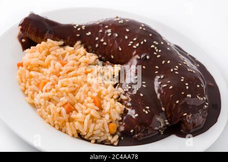 Traditional mole Poblano with rice in plate isolated on white background Stock Photo