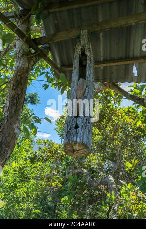 Wooden bells kulkul. A wooden bell with a mallet made from a tree trunk hung on a beam between trees on Bali Island. Balinese Hindus make bells of Stock Photo