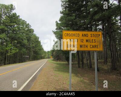 A 'crooked and steep' road warning sign in the Ouachita mountains of Mena, Arkansas Stock Photo