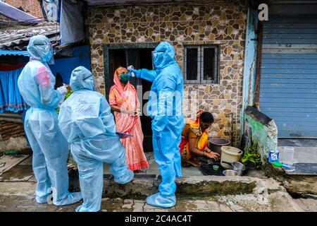 Mumbai, India/June 17, 2020: Health workers wear Personal Protective Equipment (PPE) as they check temperatures of residents of Ramabai Colony, Ghatko Stock Photo