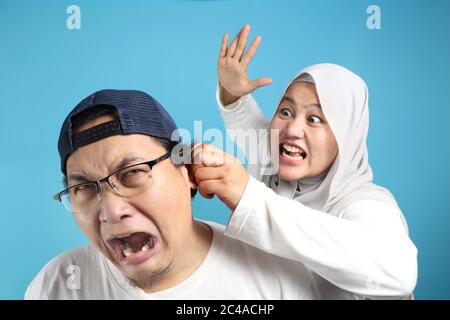 Portrait of funny Asian muslim couple having conflict, wife and