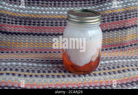 It appears like some sort of aweful fungus growing inside this jar of jelly. It will soon be thrown out as waste. Stock Photo