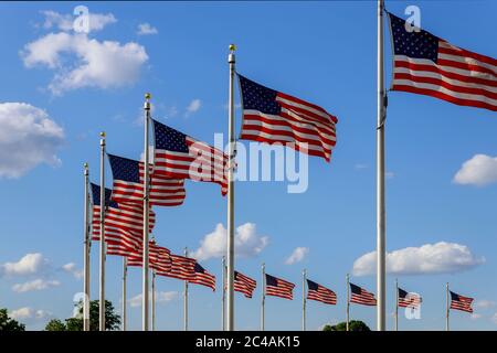 US flags waving over blue sky near Washington Monument, Washington DC USA