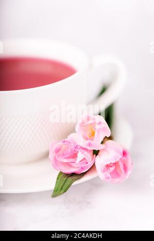 Raspberry tea and pink freesia flowers on a white background Stock Photo